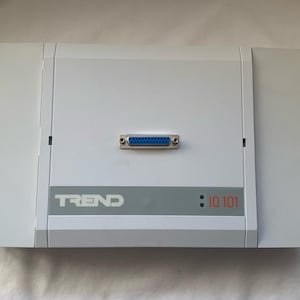 Puede incluir: Dispositivo electrónico rectangular gris claro con un conector azul y la marca "TREND" impresa. El texto "IQ 101" está impreso en rojo. Diseño limpio y moderno.