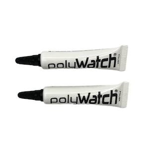 Op de afbeelding: Twee witte tubes PolyWatch horlogepoets. De tubes hebben zwarte dopjes en een zwart etiket met de tekst "PolyWatch" en "Polish" erop.