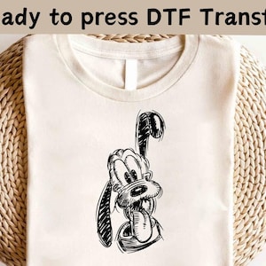 May include: A white t-shirt with a black and white illustration of Goofy's face. The text "Ready to press DTF Transfer" is at the top of the image.