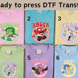 以下が含まれることがあります： 映画「インサイド・ヘッド」のキャラクターがプリントされた、明るい色のTシャツ6枚。キャラクターは、嫌悪、怒り、恐怖、ビング・ボン、喜び。Tシャツは1から6まで番号が付けられています。