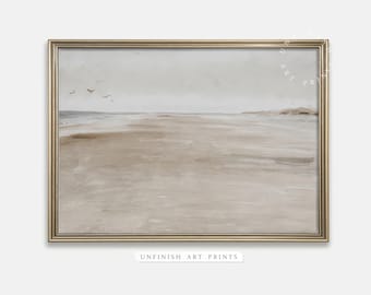 May include: A framed painting depicting a beach scene with a light grey sky and a sandy beach. The painting is in a gold frame.
