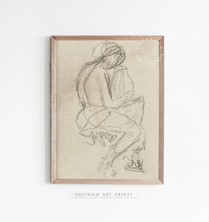 May include: A black and white pencil sketch of a person sitting with their legs crossed. The drawing is on a beige background and framed in a light wood frame.