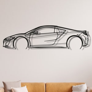 Könnte beinhalten: Eine schwarze Wandskulptur aus Metall, die ein Sportwagen im Profil zeigt. Die Skulptur ist an einer weißen Wand über einem braunen Ledersofa mit zwei Kissen angebracht.