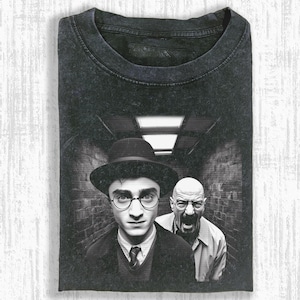 May include: Dark gray t-shirt featuring a black and white graphic of two men in a hallway. One man wears a hat and glasses, the other is yelling. The shirt has a crew neck.