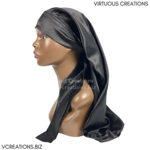 May include: A black satin bonnet with a long, flowing tail. The bonnet is worn on a mannequin head. The text "VIRTUOUS CREATIONS" is visible at the top of the image. The text "VCREATIONS.BIZ" is visible at the bottom of the image.