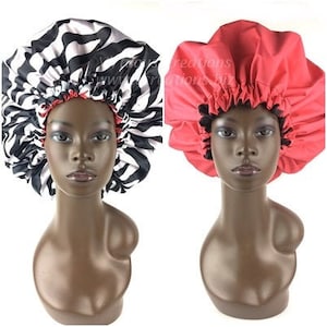 May include: Two satin bonnets, one with a zebra print and one solid red. Both bonnets are worn on mannequins with brown skin.