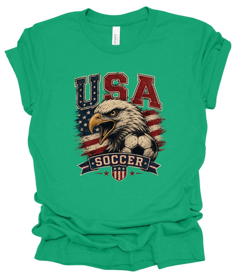 Peut inclure: Un t-shirt vert vif &agrave; manches courtes avec un motif vieilli repr&eacute;sentant un pygargue &agrave; t&ecirc;te blanche, un ballon de football et le drapeau am&eacute;ricain. Le texte USA est en rouge et bleu au-dessus, et le mot SOCCER est sur une banni&egrave;re bleue.