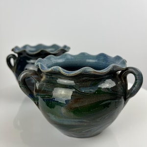 Può includere: Due vasi in ceramica blu e verde con bordi ondulati e manici. I vasi hanno una smaltatura marmorea.