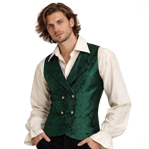 May include: A dark green double-breasted waistcoat with a floral design and gold buttons. It is worn over a cream-coloured collared shirt with ruffled cuffs. The style suggests historical or theatrical clothing, suitable for costumes or themed events.