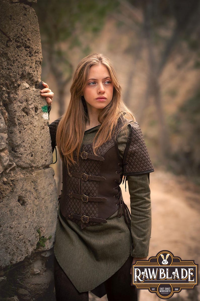 May include: A brown leather vest with a quilted design and multiple buckles. The vest has a lace-up front and is worn over a green shirt.