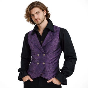 Può includere: Un gilet viola doppiopetto con un motivo floreale e bottoni dorati. È indossato sopra una camicia nera con colletto e polsini a balze. Lo stile ricorda la moda vittoriana o gotica.