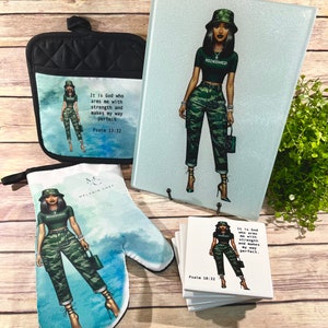 May include: A set of kitchen items featuring a woman in a green camouflage outfit and a black hat. The items include a potholder, a cutting board, and coasters. The text "REDEEMED" is on the woman's shirt and the text "It is God who arms me with strength and makes my way perfect. Psalm 18:32" is on the coasters.