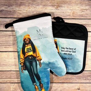 May include: A set of two oven mitts with a blue watercolor background. One mitt features a woman wearing a yellow hoodie with the words "Faith Favor Fearless" on it. The other mitt has the text "May the favor of the Lord our God rest on us Psalm 90:17".