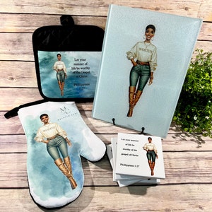 May include: A set of kitchen items featuring a woman in a stylish outfit with the word "WORTHY" on her shirt. The set includes a pot holder, oven mitt, cutting board, and coasters. The items are all decorated with a watercolor-style background and the quote "Let your manner of life be worthy of the Gospel of Christ, Philippians 1:27".