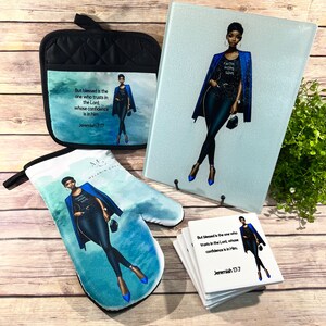 May include: A set of kitchen items featuring a woman in a blue blazer with the words "Faith Hope Love" on her shirt. The set includes a pot holder, oven mitt, cutting board, and coasters. The coasters and pot holder feature the quote "But blessed is the one who trusts in the Lord, whose confidence is in him. Jeremiah 7:17".