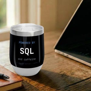 May include: A black stainless steel tumbler with a silver rim and base. The text on the front reads "POWERED BY SQL and caffeine" in white and blue lettering, with smaller text below that says "// runs on queries + coffee".