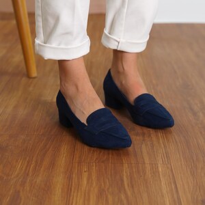 Front view of a woman standing in navy blue vegan suede low block heel loafers, capturing the sophisticated look and sleek design hyl wedding short heels.