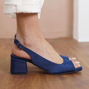 Op de afbeelding: Navyblauwe satijnen sandalen met een slingback-bandje en een blokhak.
