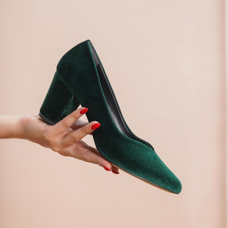Hand holding a green silky velvet bridal block heel, showcasing the sleek upper, medium high block heel, and luxurious finish by Hyl Wedding Shoes.