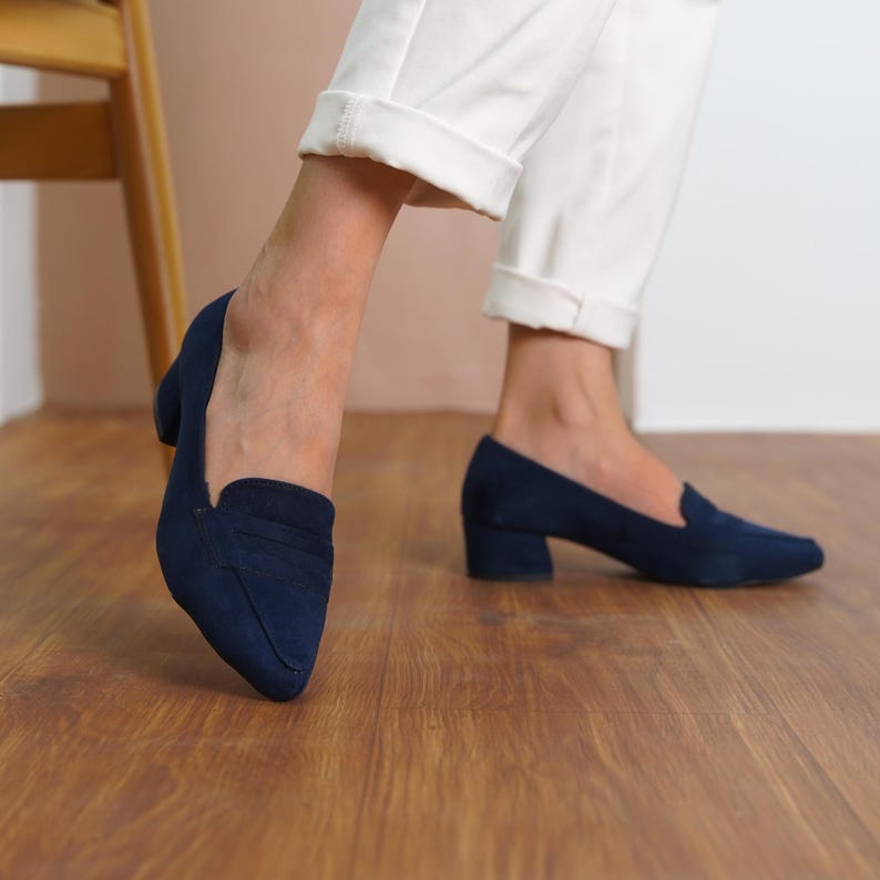 Side view of a woman walking in dark blue vegan suede bridal block low heel loafers, showcasing the sleek and stylish design hyl wedding short heels.