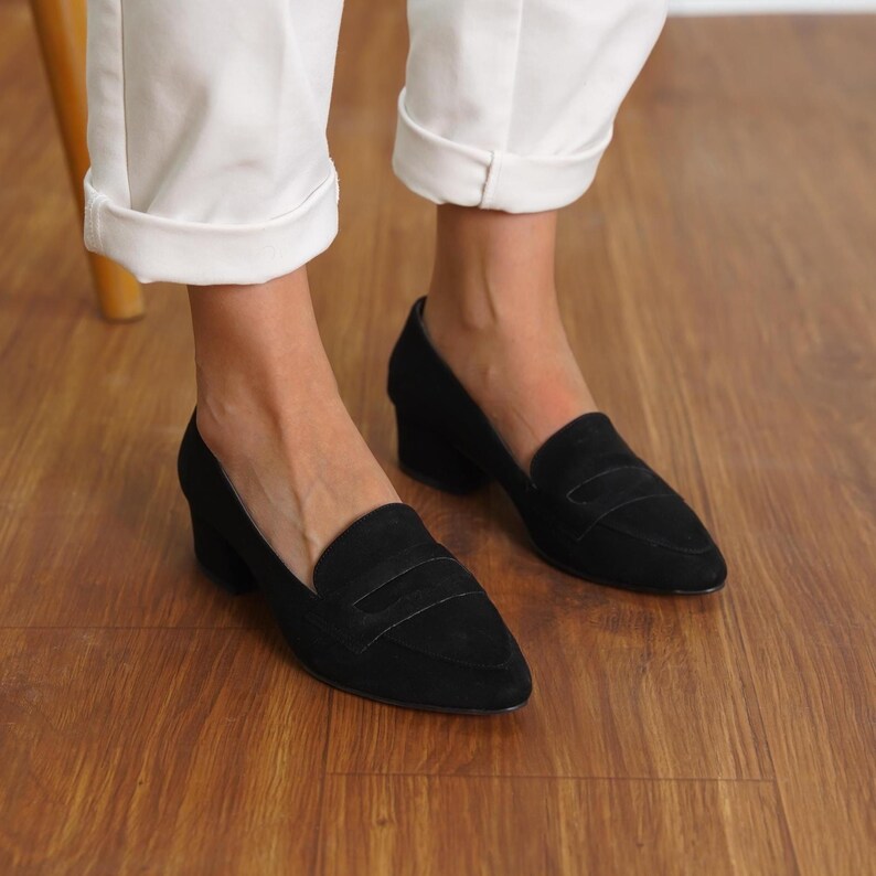 Front view of a woman standing in black vegan suede low block heel loafers, capturing the sophisticated look and sleek design hyl wedding short heels.