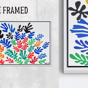 May include: A white framed print of a colorful abstract painting featuring a cluster of stylized leaves in shades of blue, green, red, orange, and yellow. The painting is titled "HM 53".