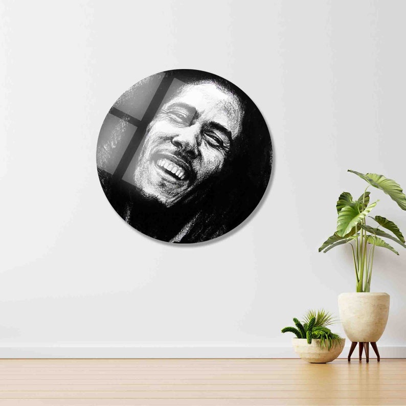 May include: Black and white illustration of a man with a beard and long hair, smiling with his eyes closed. The illustration is in a circular format.