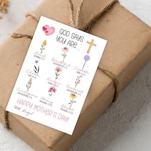 May include: A gift wrapped in brown paper and tied with twine. A white card with the text "GOD SAYS YOU ARE..." and floral illustrations is attached. The card also reads "HAPPY MOTHER'S DAY!" and "FROM: Abigail."