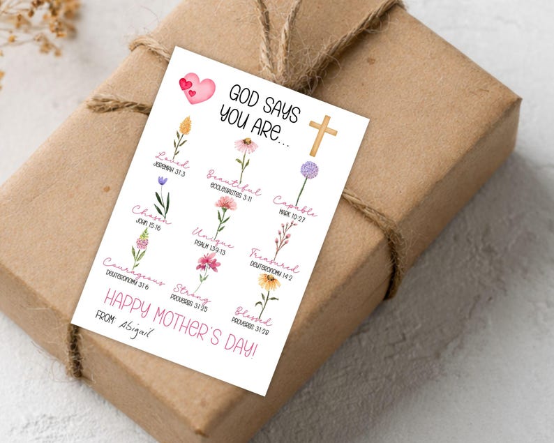 May include: A gift wrapped in brown paper and tied with twine. A white card with the text "GOD SAYS YOU ARE..." and floral illustrations is attached. The card also reads "HAPPY MOTHER'S DAY!" and "FROM: Abigail."