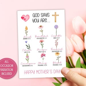 May include: A white card with the text "GOD SAYS YOU ARE..." and "HAPPY MOTHER'S DAY!" is held by a hand. The card features watercolor flowers and phrases like "Loved," "Beautiful," and "Capable." A pink heart and cross are also present.