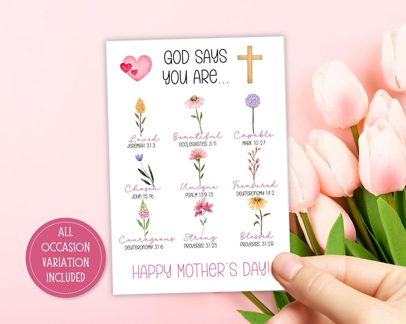 May include: A white card with the text "GOD SAYS YOU ARE..." and "HAPPY MOTHER'S DAY!" is held by a hand. The card features watercolor flowers and phrases like "Loved," "Beautiful," and "Capable." A pink heart and cross are also present.