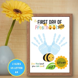May include: A framed print with the text "FIRST DAY OF Preschool 2025" and a bee graphic. The print includes handprints, a bee illustration, and the text "Bee the best you can bee!" with the name "Oliver" and "Age 5".