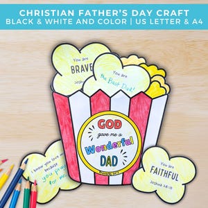 May include: A colorful Father's Day craft featuring a popcorn box design with the words "GOD gave me a Wonderful DAD." Includes heart-shaped elements with phrases like "You are BRAVE" and "You are FAITHFUL." Colored pencils are visible.