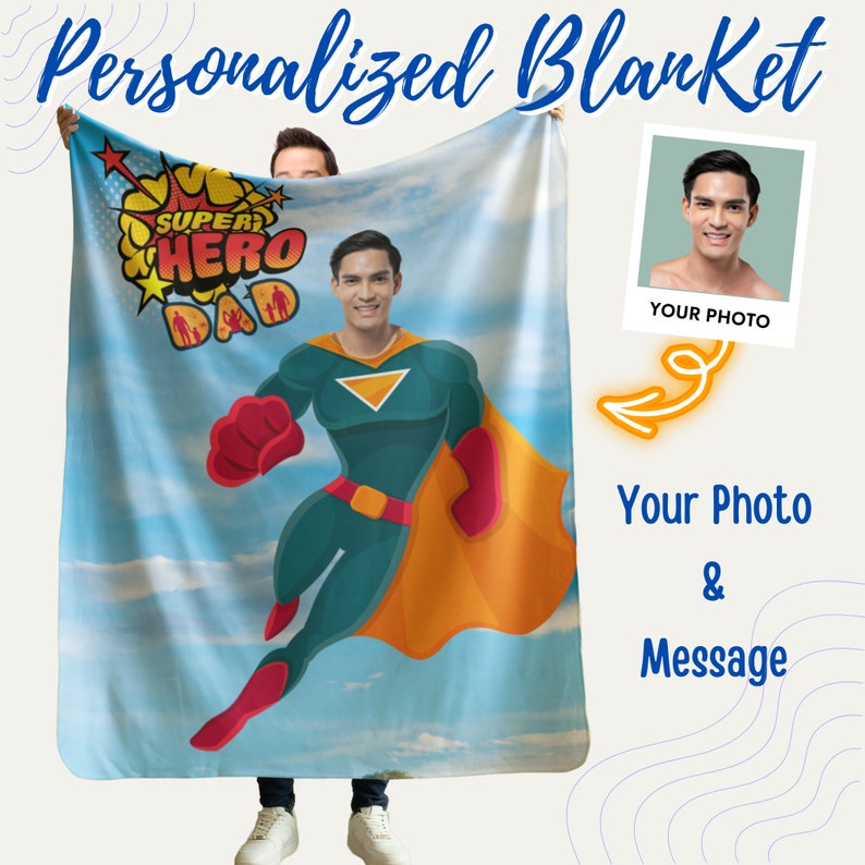 Puede incluir: Una manta personalizada con un fondo de cielo azul y una ilustraci&oacute;n de superh&eacute;roe. El superh&eacute;roe lleva un traje verde y amarillo con una capa roja. El texto "Super Hero Dad" est&aacute; en una fuente de estilo c&oacute;mic. La manta es personalizable con una foto y un mensaje.