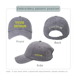 May include: A gray baseball cap with the text "YOUR DESIGN" in yellow on the front, "CUSTOM" on the back, and "CUSTOM" on the side. The cap has a curved brim and an adjustable strap.