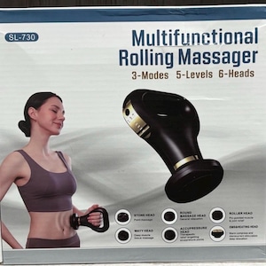 May include: A black and gold multifunctional rolling massager with the text "Multifunctional Rolling Massager" and "3-Modes 5-Levels 6-Heads". The massager is being used on a person's abdomen. The box also lists different massage head types.