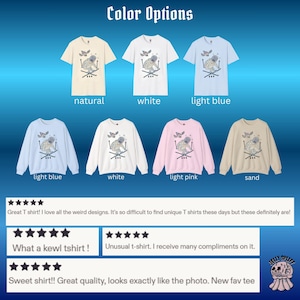 May include: A variety of t-shirts and sweatshirts in multiple colors, including natural, white, light blue, light pink, and sand. Each garment features a unique graphic design with a creature and butterflies. The text "Color Options" is at the top.
