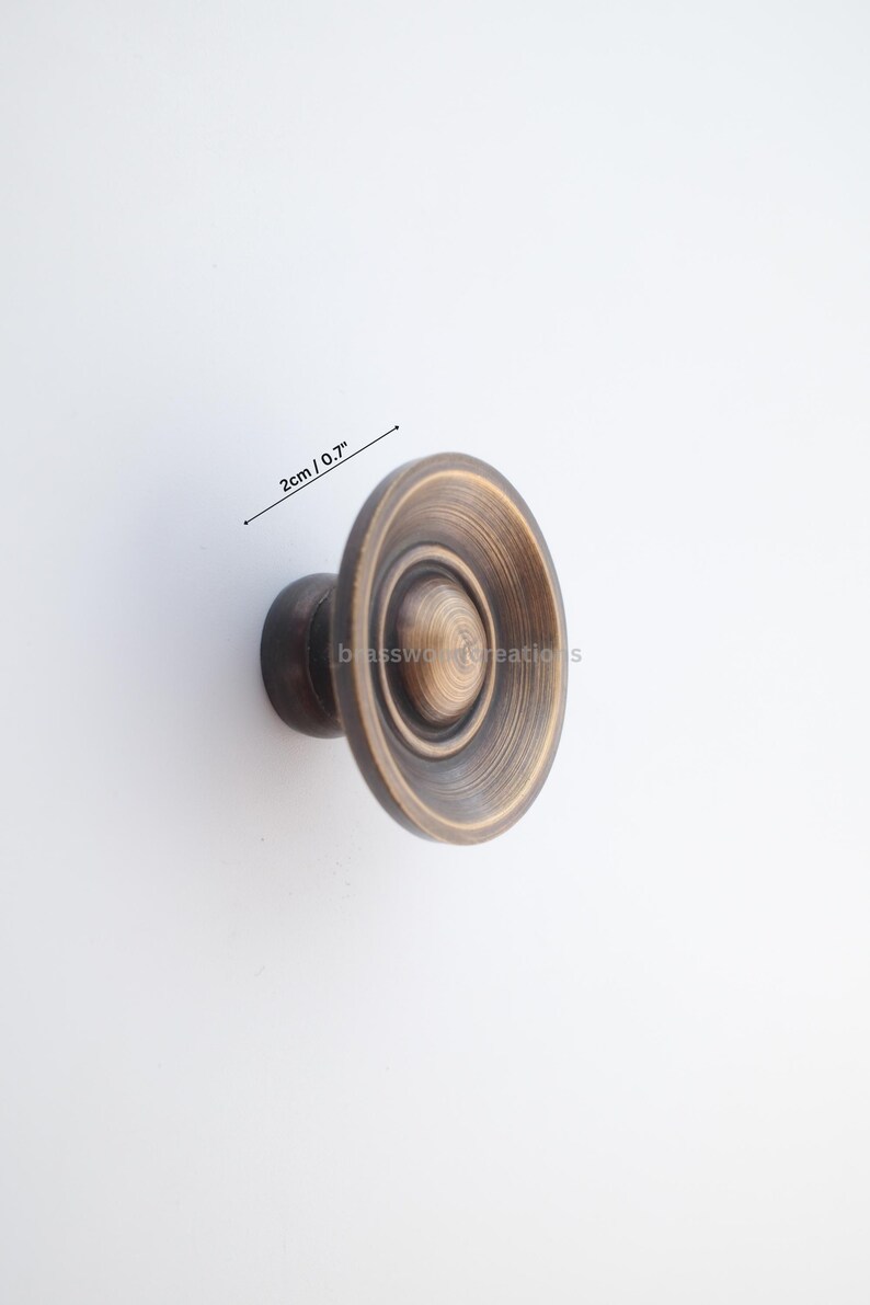 Puede incluir: Tirador de armario de bronce antiguo con dise&ntilde;o circular. El pomo mide 2 cm de di&aacute;metro. El herraje tiene un acabado en bronce oscuro y es adecuado para cajones y armarios.