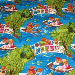 May include: A blue and green fabric with a repeating pattern of bears in boats and on bridges. The bears are wearing clothes and are fishing. The background is a blue lake with lily pads.