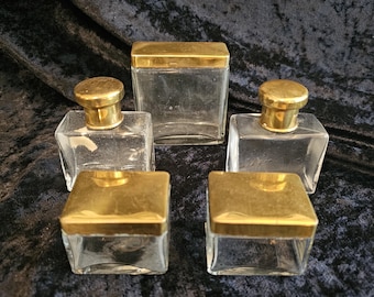 Juego de tocador vintage de 5 piezas de vidrio transparente con tapas de latón dorado y frascos para perfume.