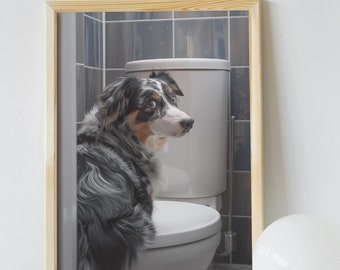 May include: A framed photograph of a blue merle Australian Shepherd dog sitting on a white toilet in a bathroom with gray tiled walls.