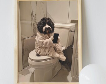 May include: A black and white dog wearing a white robe sits on a white toilet in a bathroom with white tile floors and a white bathtub. The dog is holding a black smartphone in its paws.