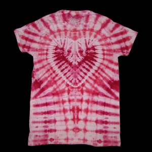 May include: A white t-shirt with a pink and red tie-dye pattern in the shape of a heart.