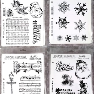 May include: Four clear plastic sheets with black and white images of Christmas-themed stamps. The stamps include images of a snowman, Santa Claus, snowflakes, a Christmas tree, a street lamp, musical notes, and the words "Happy Holidays", "Christmas Carols", "Merry Christmas", and "Seasons Greetings".