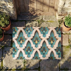 May include: A rectangular doormat featuring a repeating geometric pattern of interlocking beige arches. The interior of each arch displays a decorative tile design in shades of teal, blue, and yellow, creating a vibrant, symmetrical visual effect.
