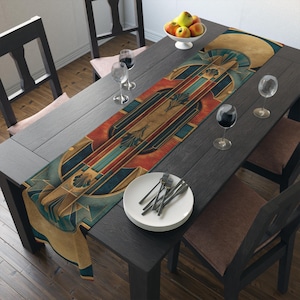 May include: An Art Deco style table runner with a geometric design in shades of teal, gold, red, and brown. The runner is placed on a dark wooden table set for a meal, with wine glasses, plates, and silverware.