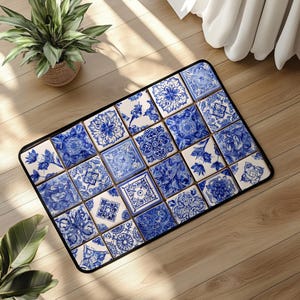 May include: Rectangular floor mat with a black border, featuring a pattern of blue and white tiles. Each tile displays a unique floral or geometric design. The mat is placed on a wooden floor.