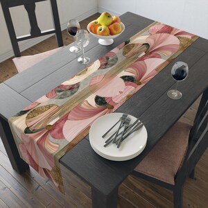 May include: A rectangular table runner featuring a repeating pattern of overlapping pink, cream, and dark green fan-shaped motifs accented with gold glitter textures and thin gold parallel lines, laid flat across a dark wooden dining table.
