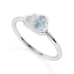 May include: A silver ring featuring a cloud-shaped setting inlaid with a marbled, iridescent stone displaying shades of white, gray, and blue. The band is smooth and polished, with the number 925 clearly engraved on the inner surface of the metal.