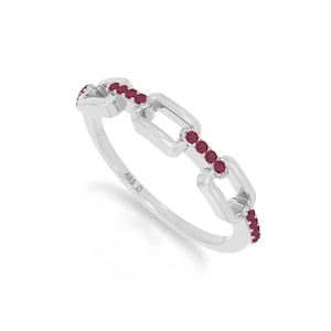 May include: A silver ring featuring a chain-link design with small, round, deep red gemstones embedded along the top surface of the links. The interior of the band is clearly stamped with the text 925, indicating the sterling silver composition.